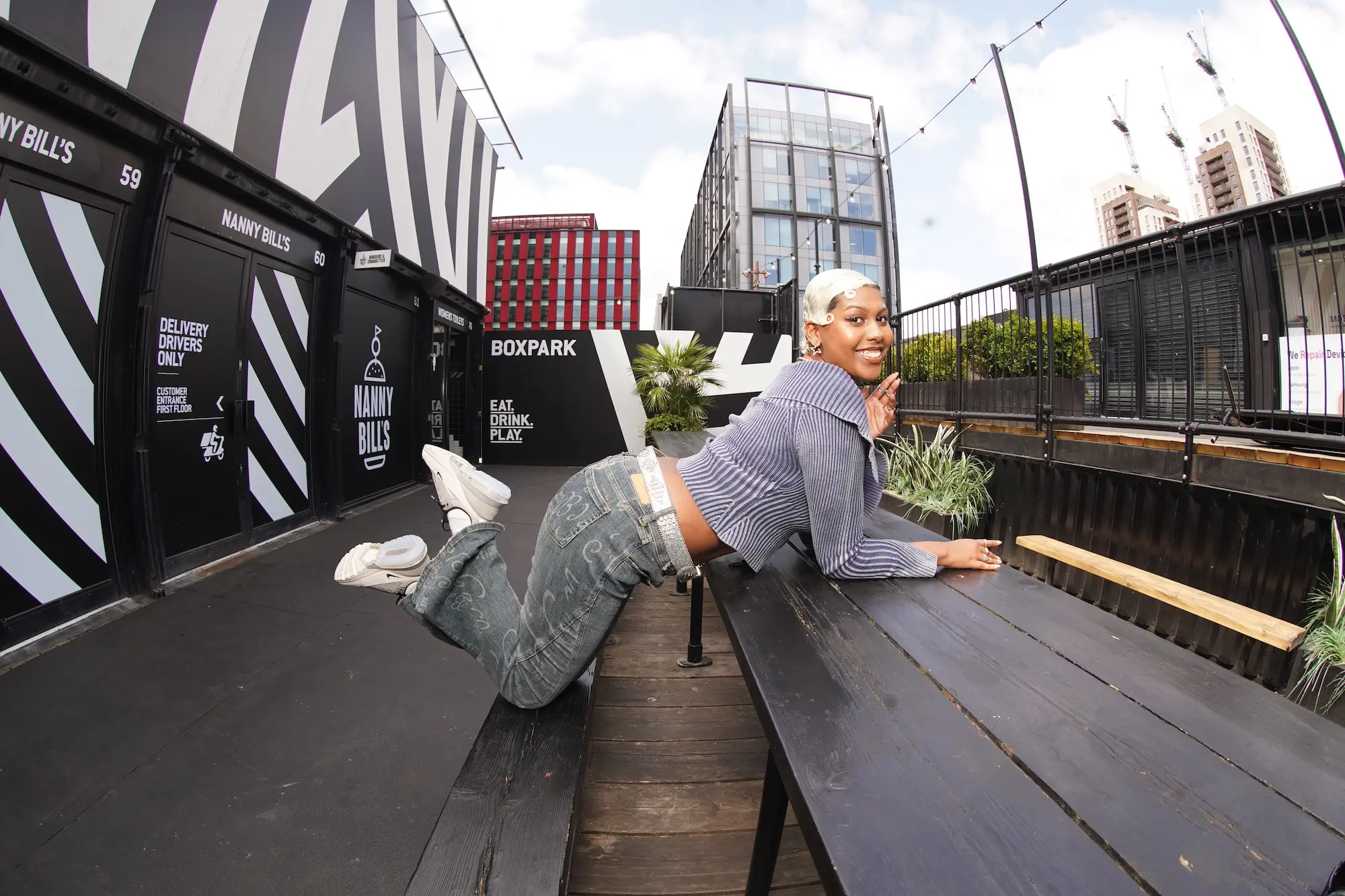 Young woman posing in East London, smiling at the camera 